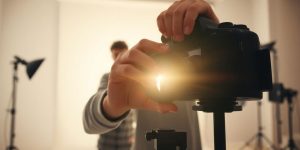 Photographer adjusting camera lens, natural light